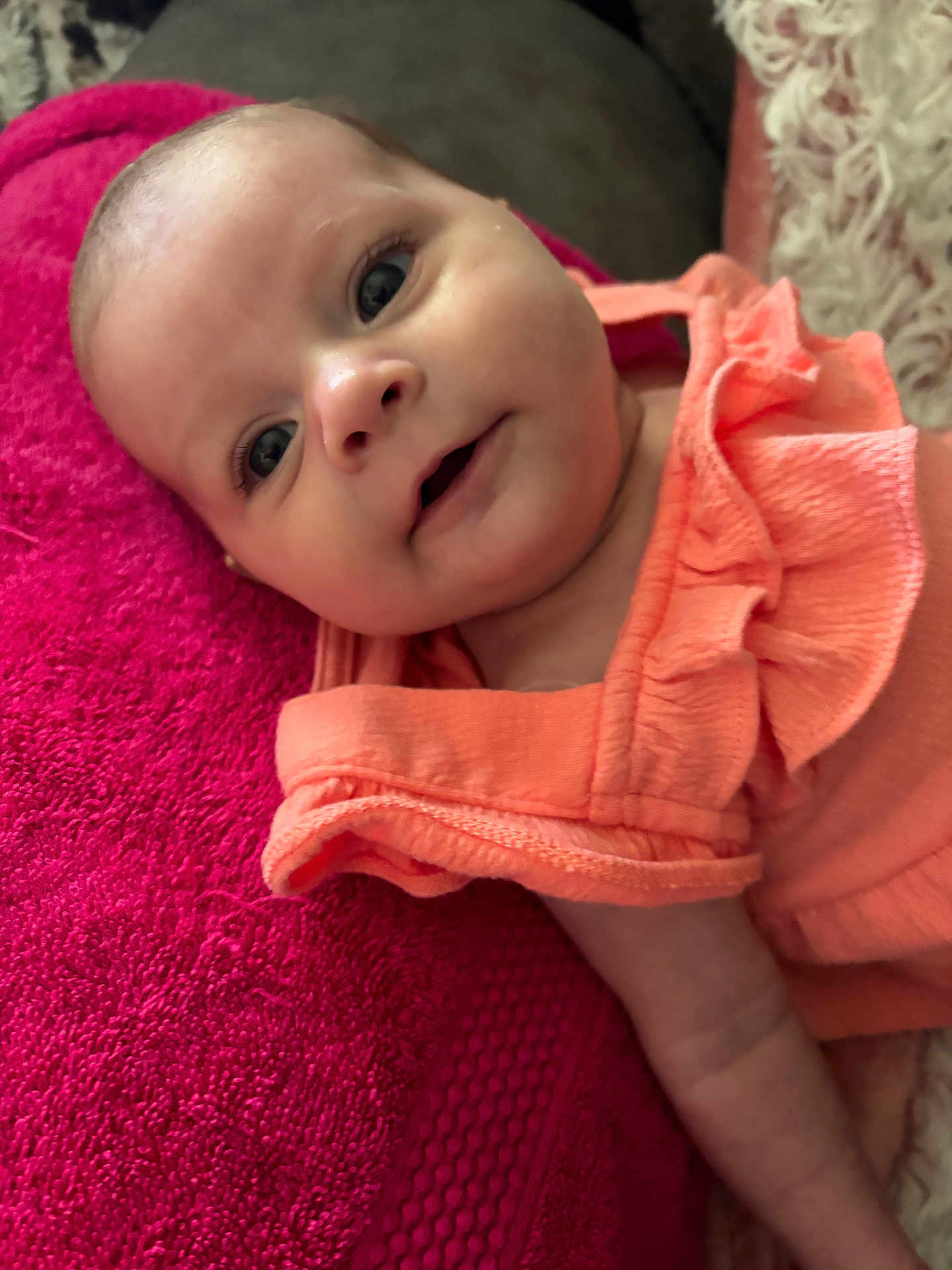 Alayna Babylove joined the competition — help win amazing prizes! baby, infant, face, child, pink_towel, orange_clothing, ruffles, portrait, cute, smile, skin, head, lying_down, young_child, indoor, closeup, expression, person, soft_texture, bright_colors
