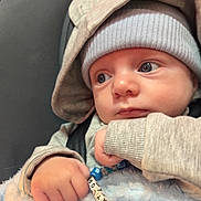 Taylor-Wayne is registered to the contest to win money with this photo: baby, infant, hat, knitwear, blanket, beads, bracelet, hand, face, blue, cute, cozy, child, portrait, closeup, expression, indoors, warm, clothing, person