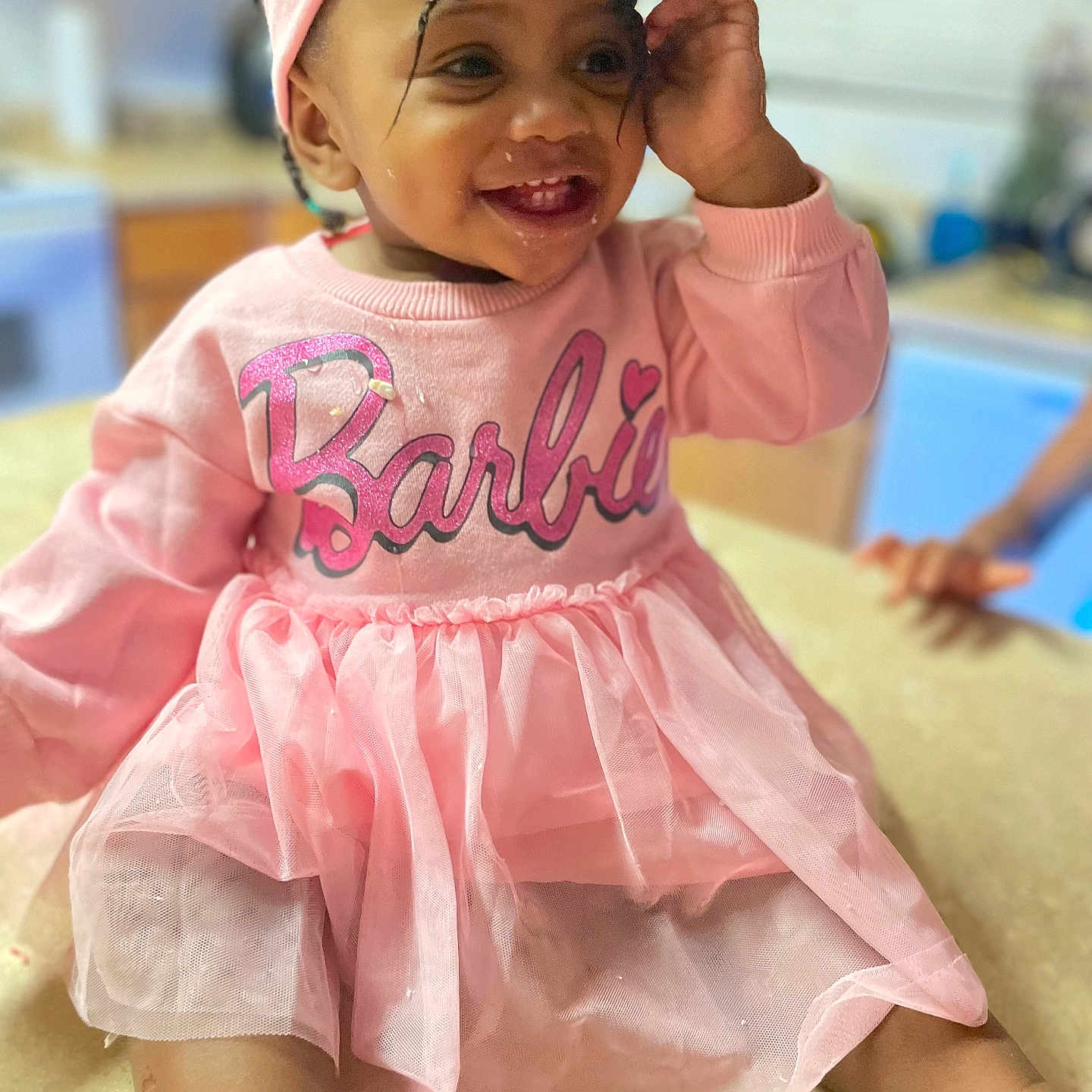 Zahrya joined the competition — help win amazing prizes! baby, barbie, child, clothing, counter, curly_hair, cute, food_on_face, fun, happy, headband, indoors, kitchen, person, pink_dress, portrait, sitting, smiling, toddler, young_child