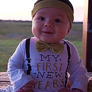 David joined the competition — help win amazing prizes! baby, bow_tie, celebration, child, clothing, face, first_new_year, happy, headband, infant, nature, outdoor, portrait, shirt, sitting, smile, sunset, table, text, wood