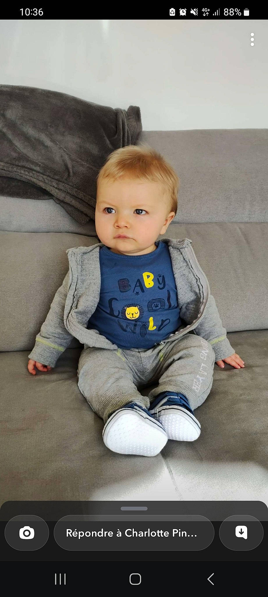 Tao participe au concours pour gagner de l'argent avec cette photo : baby, baby_toddler_clothing, chair, cheek, child, collar, comfort, couch, electric_blue, eye, floor, flooring, grey, head, outerwear, person, sitting, skin, sleeve, toddler