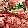 newborn, baby, smile, blanket, green_clothing, sleeping, cozy, soft_texture, infant, wrapped, cute, peaceful, indoors, portrait, child, pink, warm, resting, toddler, face