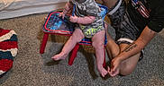 Jaeger is registered to the contest to win money with this photo: baby, child, man, tattoo, carpet, chair, camo_clothing, smile, indoor, bed, blanket, person, floor, furniture, playtime, home, cute, happy, parent, family
