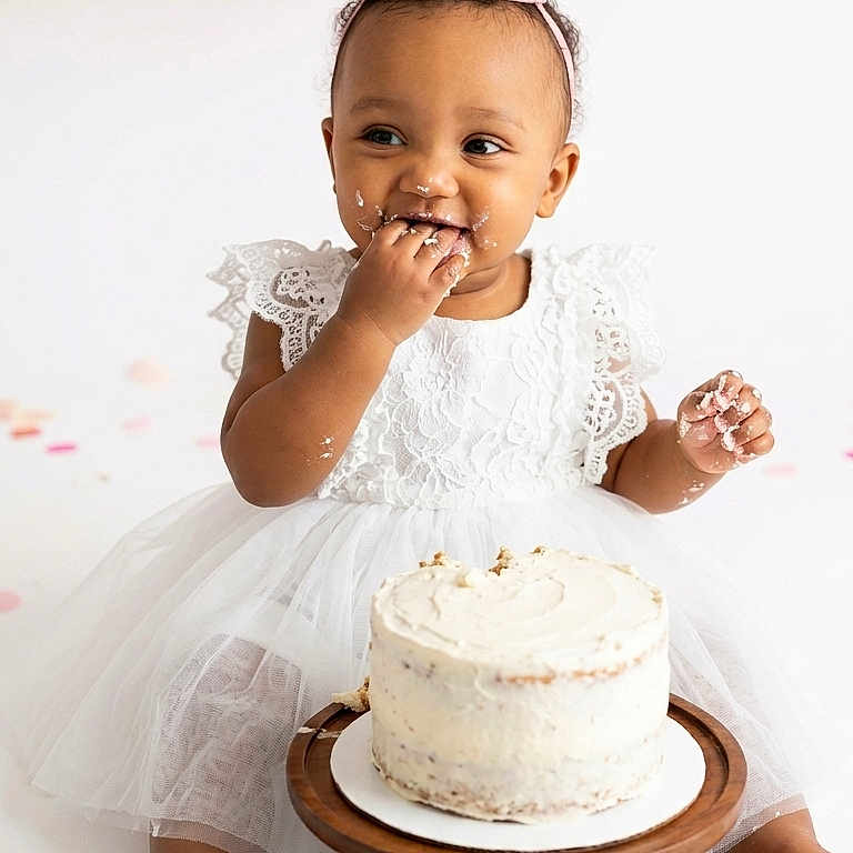 Manolie a rejoint le concours — aidez-le/la à gagner de superbes lots ! baby, child, birthday, cake, white_dress, pink_crown, smiling, frosting, first_birthday, celebration, balloons, sitting, happy, cute, party, cake_stand, messy, indoors, portrait, one_year_old