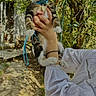 animal, being_held, blue_leash, cat, collar, foliage, fur, garden, kitten, leash, nature, outdoor, pet, portrait, stone_path, sunlight, tabby, trees, whiskers, wide_eyes