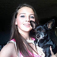 Dixie is registered to the contest to win money with this photo: woman, dog, pet, portrait, selfie, smiling, indoor, long_hair, earrings, black_dog, small_dog, holding_pet, casual, young_adult, face, human, animal, friendship, companion, cute