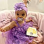 baby, purple_dress, headband, flower, pacifier, butterfly, sitting, pink_blanket, soft_toy, milestone_card, indoors, child, cute, smiling_eyes, infant, decor, toy, portrait, cozy, happy
