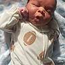 Clark Harris Jr joined the competition — help win amazing prizes! baby, infant, onesie, football_pattern, blanket, sleeping, cute, face, hand, soft_texture, newborn, child, pajamas, cozy, indoor, portrait, relaxed, expression, light, warmth