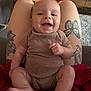 Grayson joined the competition — help win amazing prizes! baby, smiling, infant, tattoo, legs, clothing, onesie, person, happy, indoor, living_room, furniture, table, carpet, face, skin, arm, foot, hand, casual