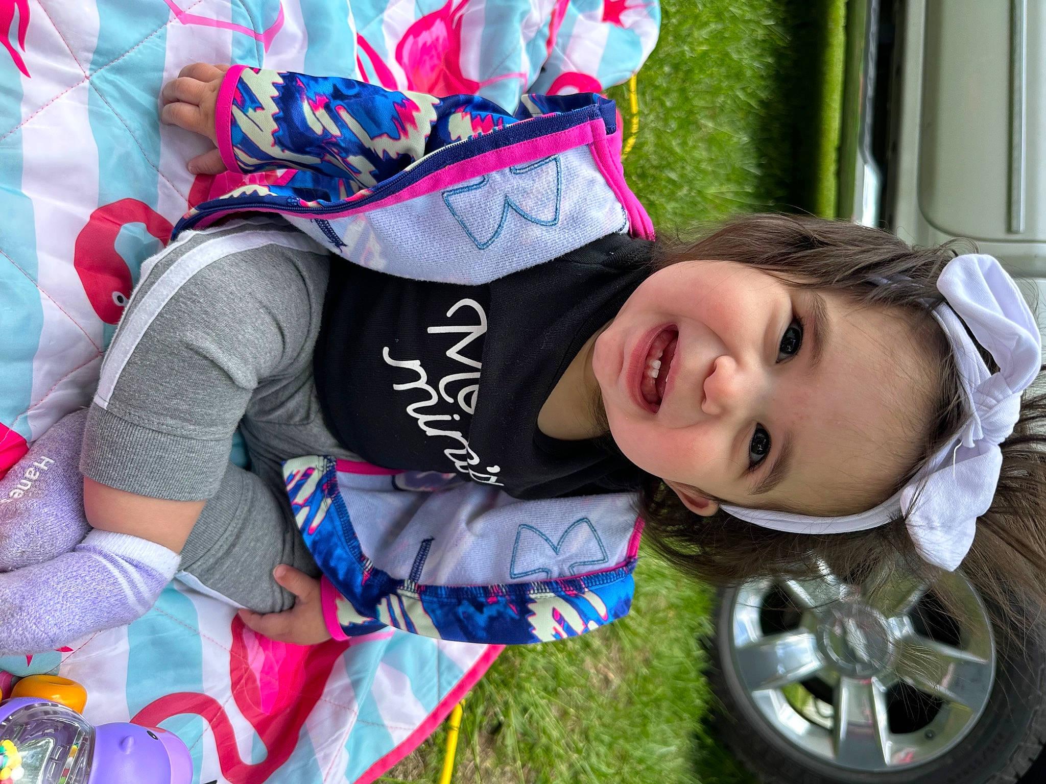 Sutton is registered to the contest to win money with this photo: automotive_exterior, automotive_tire, child, electric_blue, fashion_accessory, fun, grass, happy, joy, leisure, motor_vehicle, person, plant, recreation, rim, smile, tire, toddler, tree, vehicle_door