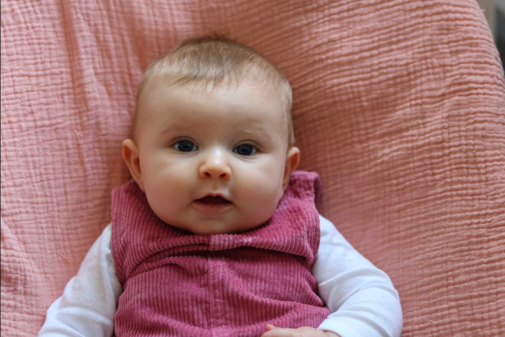 Ambre participe au concours pour gagner de l'argent avec cette photo : baby, infant, portrait, face, pink_blanket, corduroy_outfit, cheeks, blue_eyes, close_up, sleeve, soft_texture, indoor, cute, young_child, gaze, skin, head, small_hands, smiling_expression, cozy