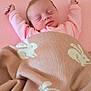 newborn, baby, sleeping, pink, blanket, knitted_blanket, bunny_pattern, arms_stretched, cozy, soft, infant, cute, peaceful, lying_down, indoor, child, portrait, sleepwear, resting, toddler
