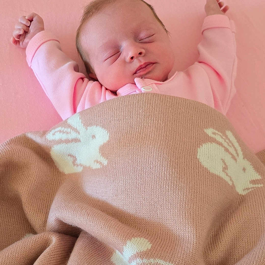 Ruairi-Rae joined the competition — help win amazing prizes! arms_stretched, baby, blanket, bunny_pattern, child, cozy, cute, indoor, infant, knitted_blanket, lying_down, newborn, peaceful, pink, portrait, resting, sleeping, sleepwear, soft, toddler