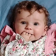 Noëly participe au concours pour gagner de l'argent avec cette photo : baby, child, curly_hair, face, fingers, floral_clothing, pink, portrait, cute, infant, lying_down, soft_texture, adorable, young_child, smiling_eyes, close_up, indoors, person, happy, toddler