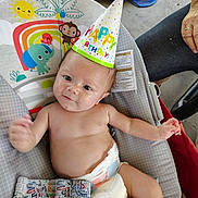 Apollo joined the competition — help win amazing prizes! baby, birthday_hat, diaper, baby_seat, animal_print, rainbow, smile, hand, clothing, indoor, person, colorful, cute, celebration, infant, seat, toy, fabric, face, child