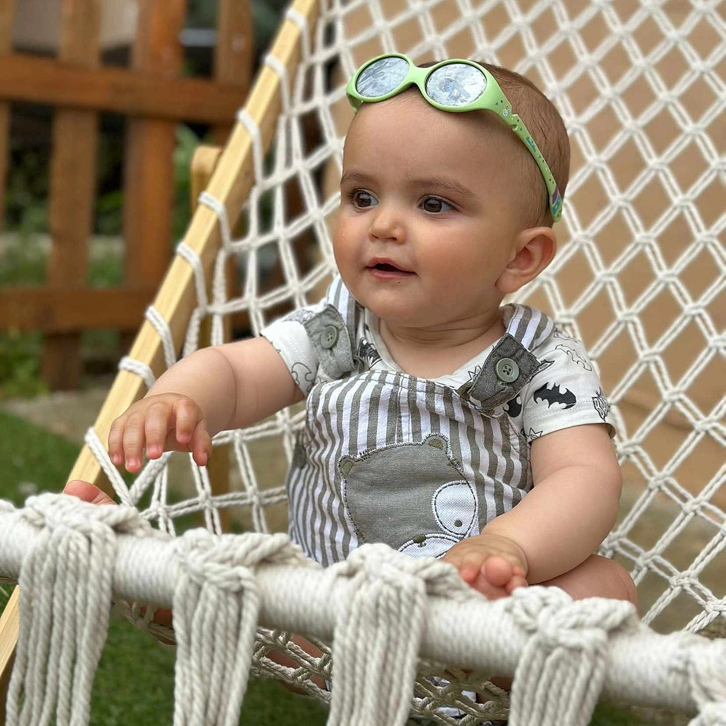 Liam a rejoint le concours — aidez-le/la à gagner de superbes lots ! baby, casual, child, cute, greenery, hammock, happy, infant, outdoor, playful, portrait, relaxed, rope, seat, smiling, striped_clothing, summer, sun_protection, sunglasses, wooden_fence