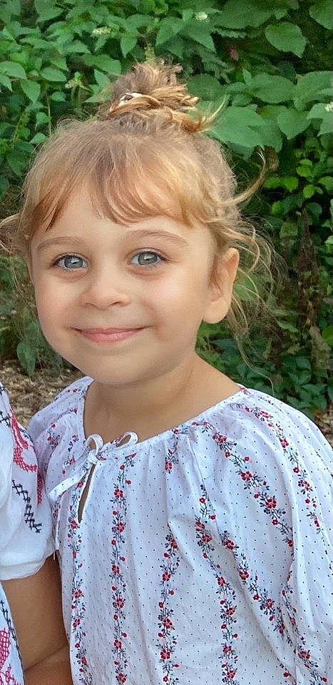 Rebeca is registered to the contest to win money with this photo: cheek, child, chin, eyebrow, eyelash, forehead, grass, green, hair, happy, head, iris, joy, lip, nose, people_in_nature, person, plant, skin, sleeve