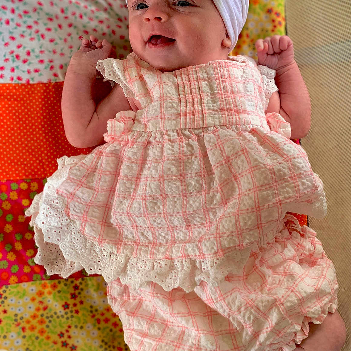 Kaelynn joined the competition — help win amazing prizes! baby, bodypart, bonnet, cap, clothing, couch, dress, face, furniture, hat, head, homedecor, linen, newborn, pants, person, photography, portrait, quilt, sitting