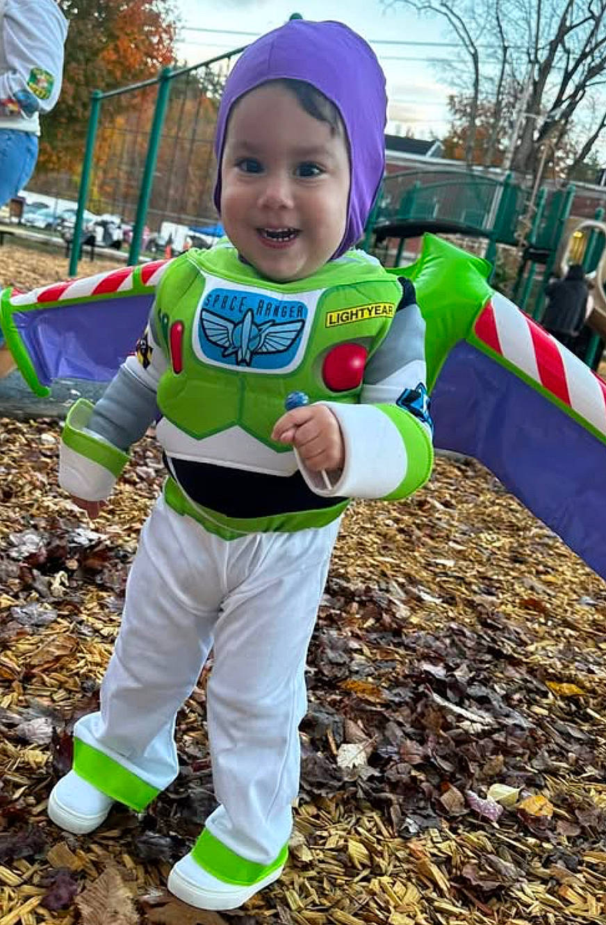 Romeo joined the competition — help win amazing prizes! buzz_lightyear, child, costume, daylight, face, fall, full_body, green, happy, leaves, outdoor, park, person, playground, purple_hood, red_buttons, smiling, toddler, toy_story, white_pants