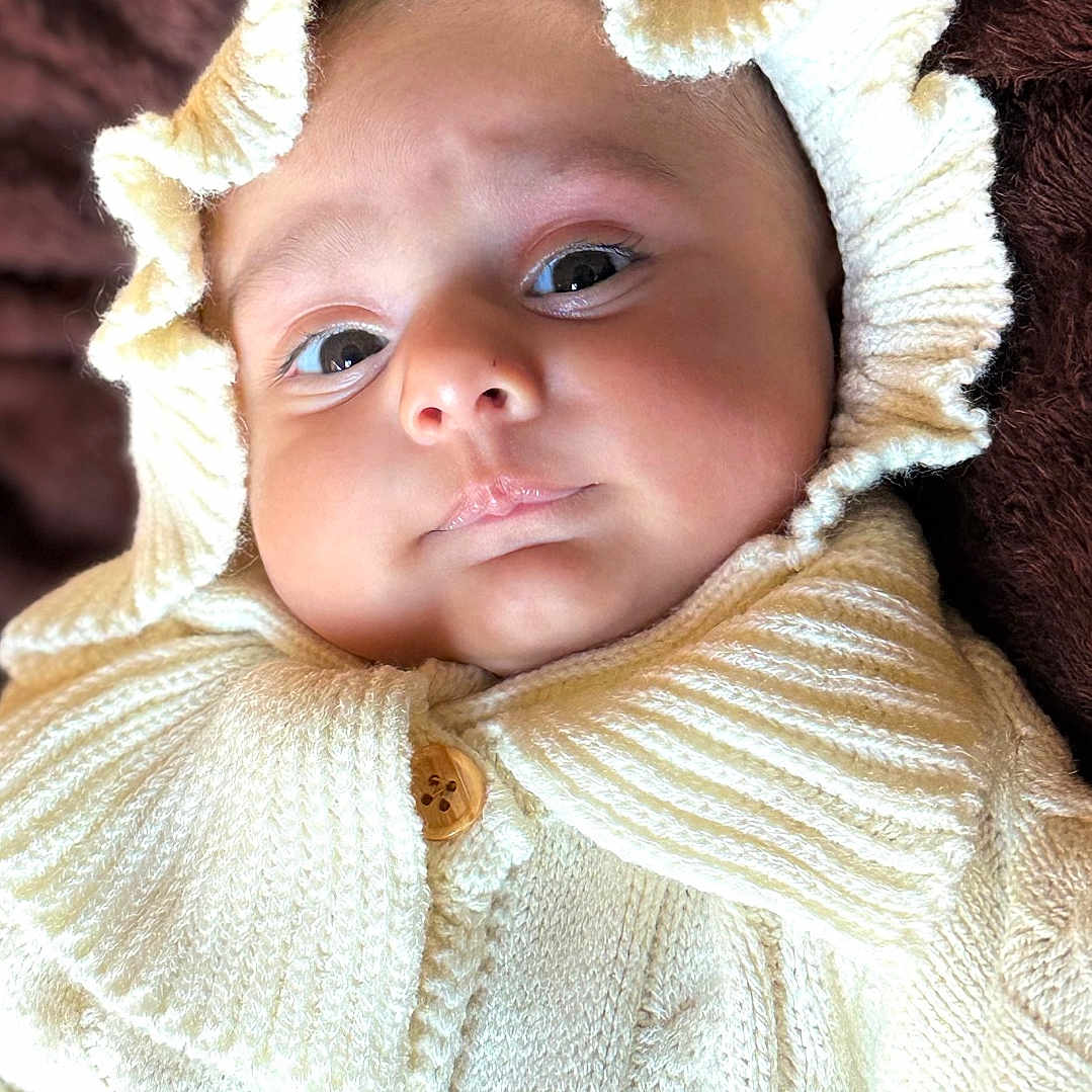 Nawaab joined the competition — help win amazing prizes! baby, blanket, button, child, close_up, cozy, cream_color, cute, eyes, face, frill, hood, indoors, infant, knitted_clothing, newborn, portrait, pout, soft_texture, warm