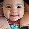 baby, child, smiling, face, car_seat, seatbelt, colorful_clothing, infant, happy, cute, portrait, safety, straps, close_up, person, indoors, young_child, head, eyes, mouth