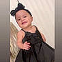 accessory, baby, black_dress, bow, celebration, child, cute, elegant, face, fashion, happy, headband, indoor, infant, joy, person, portrait, skin, smile, toddler
