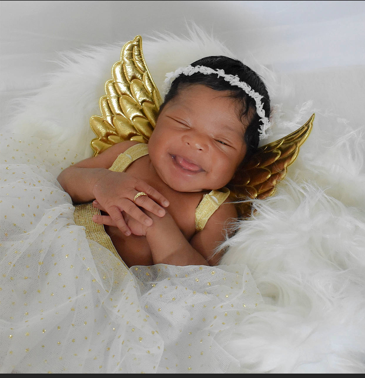 Kylah is registered to the contest to win money with this photo: arm, baby, baby_toddler_clothing, bridal_accessory, comfort, eye, eyelash, feather, flash_photography, gesture, hand, happy, head, headband, headgear, headpiece, iris, person, smile, textile