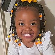 Jenesis joined the competition — help win amazing prizes! child, toddler, smiling, braids, beads, yellow_bow, white_shirt, sun_print, happy, portrait, indoor, cute, young_child, person, face, hair_accessory, bright_eyes, cheerful, closeup, fashion