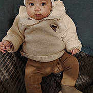 Méyya participe au concours pour gagner de l'argent avec cette photo : baby, blanket, child, comfortable, couch, cozy, cute, face, hat, headwear, indoor, infant, knitwear, looking, pants, person, portrait, seated, socks, sweater