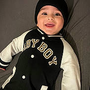 Ayden a rejoint le concours — aidez-le/la à gagner de superbes lots ! apparel, baby, beanie, black_and_white, buttoned, child, clothing, cute, face, happy, hat, infant, jacket, lying_down, person, portrait, sleeves, smiling, text_on_clothing, tongue