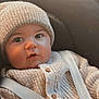 Solann a rejoint le concours — aidez-le/la à gagner de superbes lots ! apparel, baby, beige, buttoned_sweater, child, chubby_cheeks, close_up, cozy, curious_eyes, cute, face, indoors, infant, knitted_hat, knitted_sweater, portrait, seat, soft_lighting, straps, warm_clothing