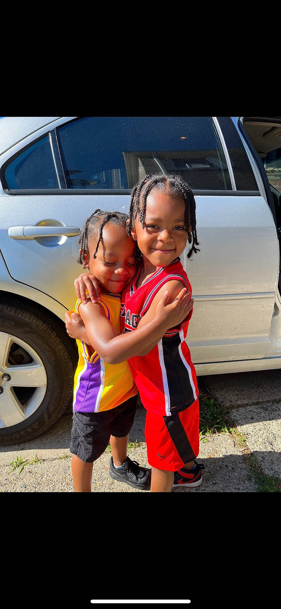 Darrin is registered to the contest to win money with this photo: alloy_wheel, automotive_design, automotive_exterior, automotive_lighting, automotive_tire, bumper, car, happy, headwear, hood, joy, land_vehicle, motor_vehicle, person, personal_luxury_car, rim, shorts, smile, tire, toddler