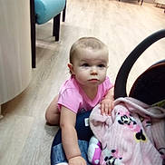 Faith joined the competition — help win amazing prizes! baby, child, pink_shirt, blanket, crawling, floor, indoor, wooden_floor, chair, furniture, curious, person, infant, car_seat, soft_toys, plaid, pattern, cute, young, exploring