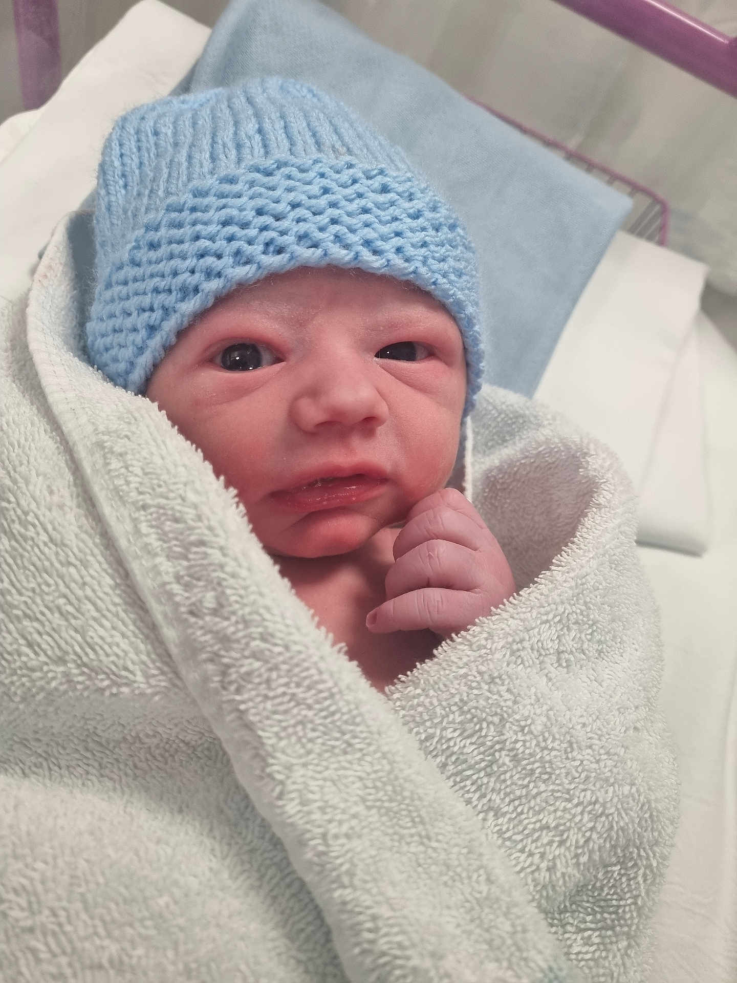 Lorenzo joined the competition — help win amazing prizes! newborn, baby, infant, wrapped, towel, blue_hat, hand, face, hospital, bed, blanket, skin, person, cute, sleepwear, portrait, closeup, cozy, soft, newborn_baby