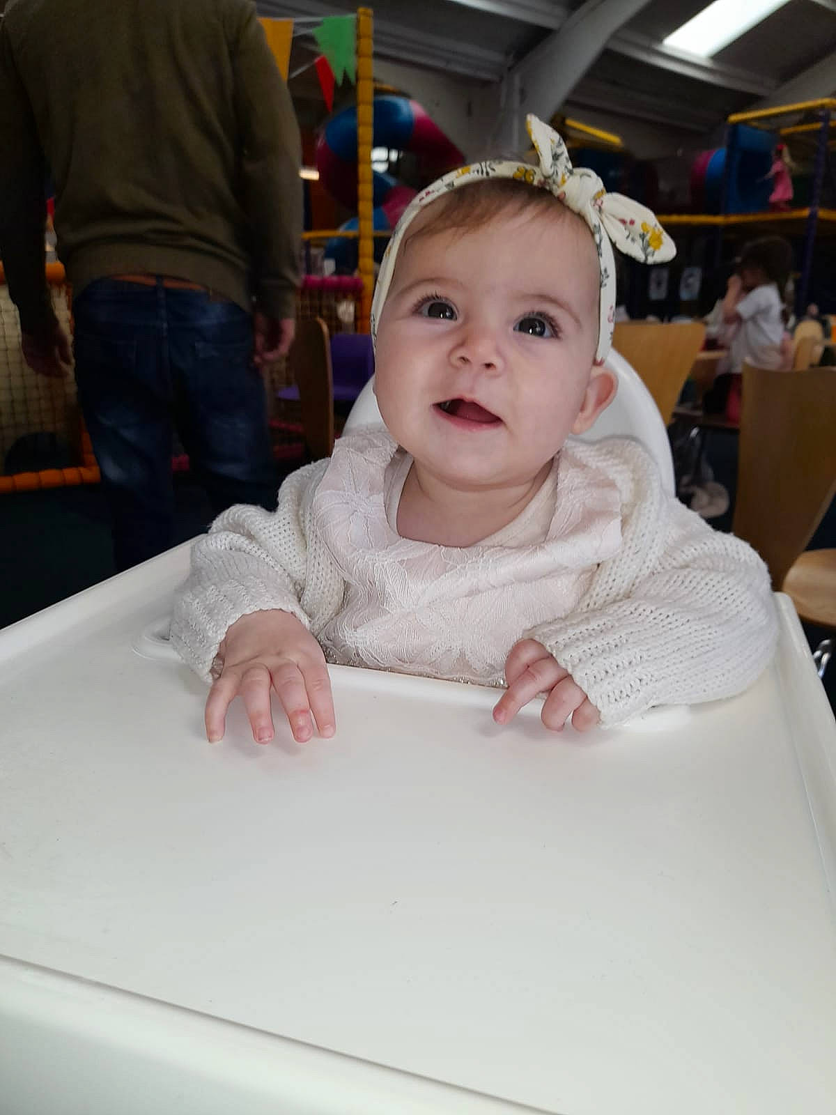 Ellie Mae is registered to the contest to win money with this photo: baby, baby_toddler_clothing, chair, cheek, child, event, flooring, formal_wear, fun, happy, leisure, person, recreation, room, sitting, skin, sleeve, smile, t_shirt, textile