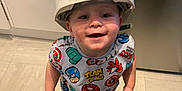 Paddy joined the competition — help win amazing prizes! adult_hand, barefoot, captain_america, child, clothing, construction_helmet, floor_tiles, happy, helmet, indoor, kitchen, looking_up, person, playful, shorts, smile, spiderman, superhero_shirt, tattoo, toddler