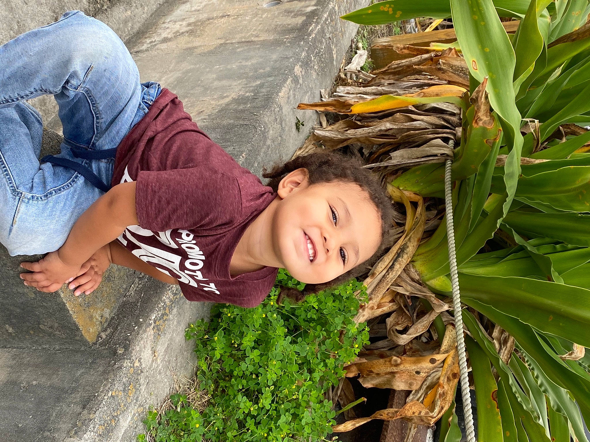 Kaine is registered to the contest to win money with this photo: adaptation, arecales, fun, grass, grass_family, happy, hat, joy, landscape, leaf, leisure, palm_tree, people_in_nature, person, plant, smile, t_shirt, terrestrial_plant, toddler, tree