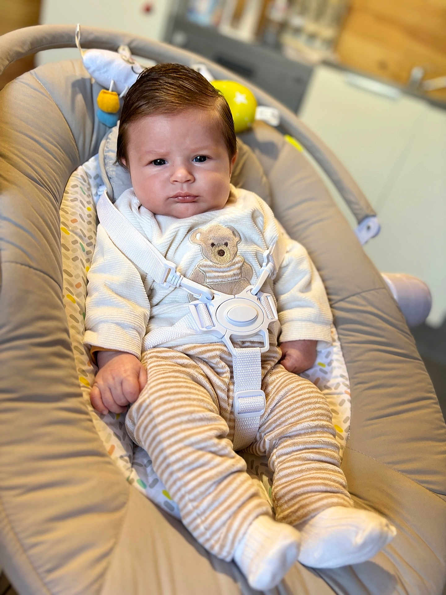 Enzo participe au concours pour gagner de l'argent avec cette photo : baby, infant, child, face, clothing, sweater, pants, striped_pants, teddy_bear, baby_seat, seatbelt, indoor, person, cute, serious_expression, soft_toys, comfort, closeup, cozy, portrait