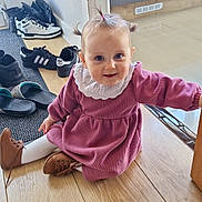 Kléo a rejoint le concours — aidez-le/la à gagner de superbes lots ! baby, blue_eyes, brown_shoes, cabinet, child, hardwood_floor, indoor, kitchen, pigtails, pink_dress, playful, portrait, shoes, sitting, slippers, smile, sneakers, toddler, white_collar, young_child