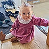 baby, blue_eyes, brown_shoes, cabinet, child, hardwood_floor, indoor, kitchen, pigtails, pink_dress, playful, portrait, shoes, sitting, slippers, smile, sneakers, toddler, white_collar, young_child