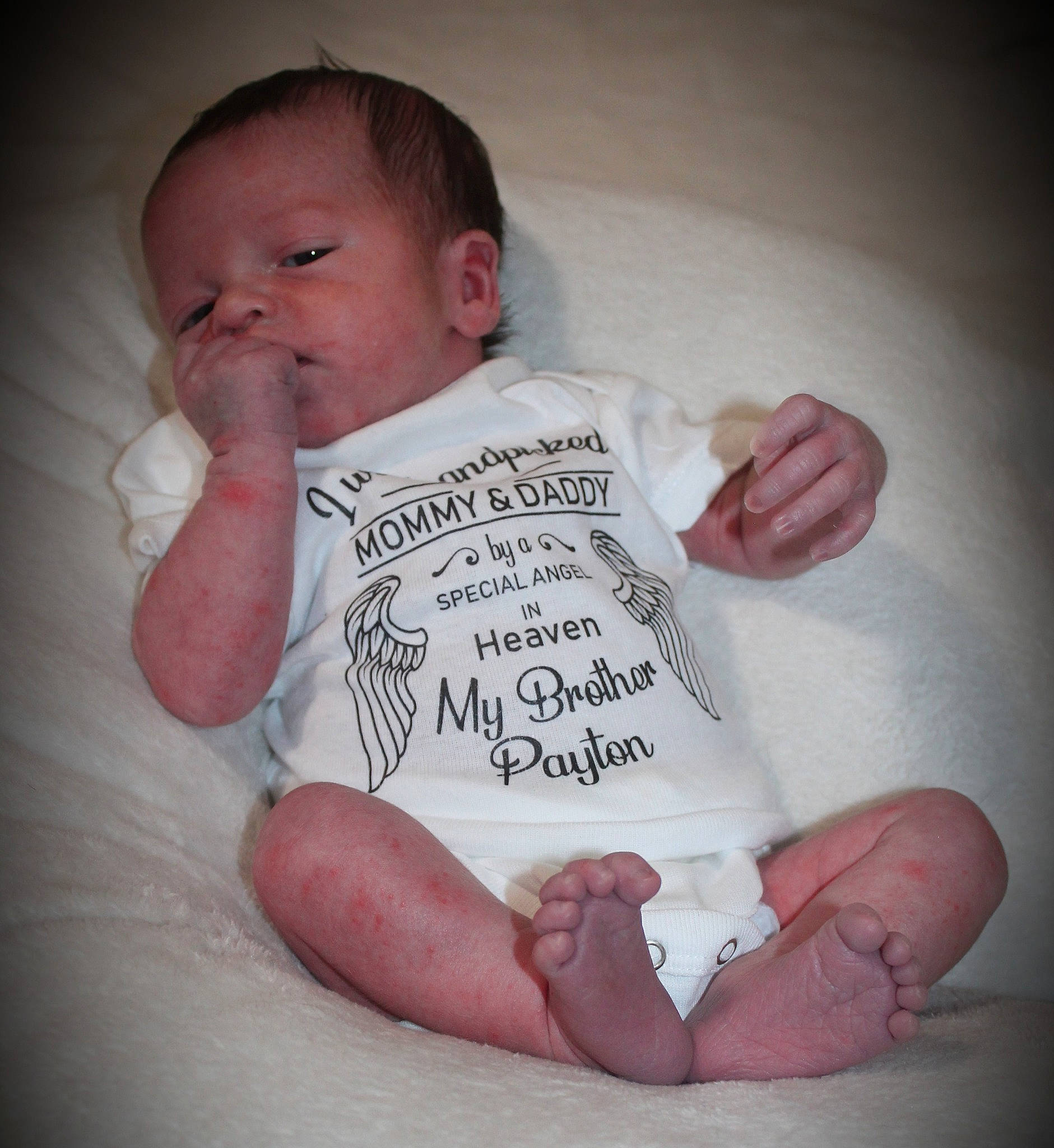 Kellen is registered to the contest to win money with this photo: arm, baby, baby_toddler_clothing, cheek, chin, comfort, ear, eye, eyebrow, hand, human_body, lip, mouth, neck, nose, person, product, skin, sleeve, stomach