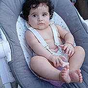 Ghita participe au concours pour gagner de l'argent avec cette photo : baby, baby_chair, baby_seat, bare_chest, blanket, bottle, bracelet, child, curious, curly_hair, cushion, expression, floor, foot, hand, indoors, infant, person, pink_bottle, tricycle