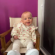 Livia participe au concours pour gagner de l'argent avec cette photo : baby, child, smile, chair, wooden_chair, purple_wall, sweater, heart_pattern, white_shoes, indoor, floor, happy, cute, person, portrait, seated, clothing, face, infant, footwear