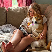 Vulpix Rose joined the competition — help win amazing prizes! child, dog, shiba_inu, couch, controller, living_room, curtains, red_curtains, pillow, barefoot, relaxed, indoor, casual, pet, comfort, home, blond_hair, seated, human, animal