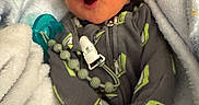 Davier joined the competition — help win amazing prizes! baby, infant, child, yawning, portrait, face, pacifier, blanket, bundled_up, sleeping, cozy, indoors, onesie, clothing, gray_outfit, green_accents, soft_blanket, close_up, nursery, candid