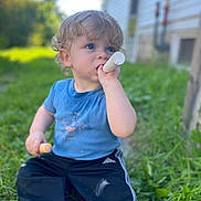 Luke joined the competition — help win amazing prizes! child, toddler, curly_hair, blue_eyes, chalk, outdoor, grass, casual_clothing, blue_shirt, black_pants, adidas, sidewalk, house, daylight, nature, sitting, play, curious, cute, young_child