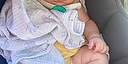 Valerie is registered to the contest to win money with this photo: baby, blanket, car_seat, sleeping, infant, child, cozy, comfort, soft_light, peaceful, wrapped, cute, skin, hand, foot, pacifier, fabric, closeup, indoors, resting