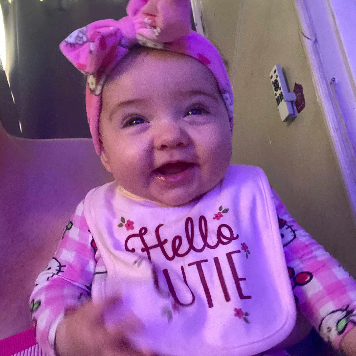 Leilani joined the competition — help win amazing prizes! baby, child, smiling, pink_bow, headband, bib, hello_cutie, pajamas, hello_kitty, indoor, person, happy, cute, infant, clothing, sitting, face, portrait, childhood, cozy