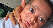 Lal Tapp is registered to the contest to win money with this photo: adult_hand, baby, casual, child, closeup, curiosity, equipment, face, floor, garage, hand, holding, indoor, infant, person, portrait, skin, tank_top, white_clothing, wide_eyes