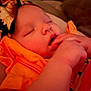 Penelope is registered to the contest to win money with this photo: baby, sleeping, hand, face, headband, orange_clothing, indoor, infant, cute, peaceful, closeup, child, portrait, skin, young, resting, adorable, soft_light, person, head